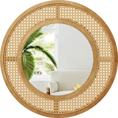 A round mirror with a rattan frame and a wooden border, reflecting a room with a palm tree and a sofa.