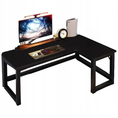 A black L-shaped desk with a monitor, keyboard, mouse, clock, and game console.