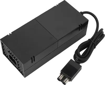 A black power adapter for an Xbox One console is shown on a white background.