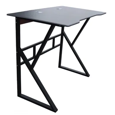 A black gaming computer desk with a metal frame, shown from a three-quarter angle against a white background.