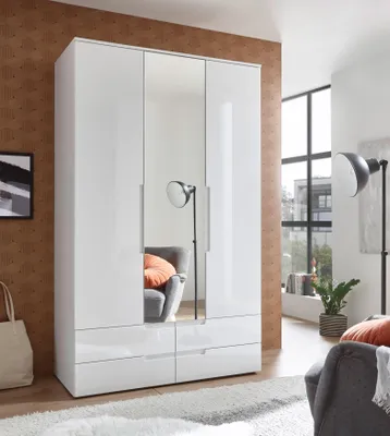 A modern bedroom with a white, high-gloss wardrobe with mirrored doors, a gray armchair with an orange cushion, and a floor lamp.