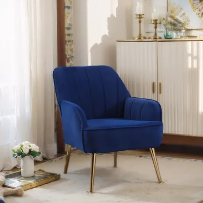 A blue armchair with gold legs is placed on a light-colored rug in a room with a white cabinet in the background.