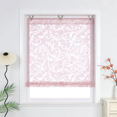 A pink patterned roller blind hanging in a white window frame.