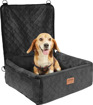 A dog sits in a black car seat booster.