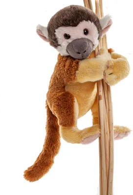 A plush toy monkey is hanging from several wooden sticks against a white background.