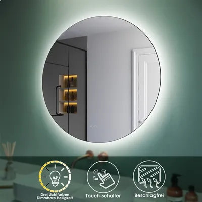 A round LED mirror with illuminated edges, reflecting a bathroom interior. Below the mirror are three icons with text describing features.