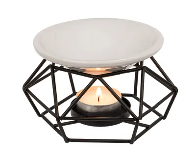 A white ceramic bowl sits on a black geometric metal stand, with a lit tea light candle underneath.