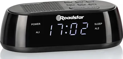A black digital alarm clock with a digital display showing the time and various buttons on top.