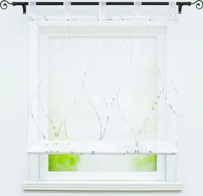 A transparent white curtain with silver wavy stripes hangs on a window.