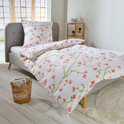 A neatly made bed with floral patterned bedding in a bedroom setting.