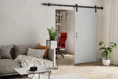 A modern living room with a sliding door leading to an office space.