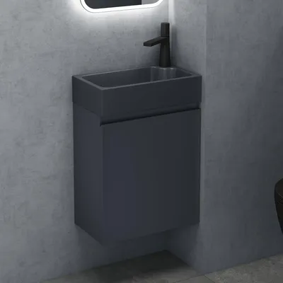 A modern bathroom vanity with a sink and faucet against a concrete wall.