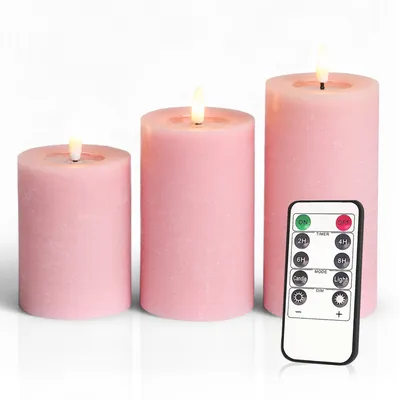 Three pink LED candles of varying heights are displayed on a white background, with a remote control in the foreground.