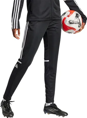 A person wearing Adidas training pants and holding a soccer ball.