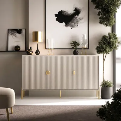 A modern living room with a sideboard, lamps, artwork, and plants.