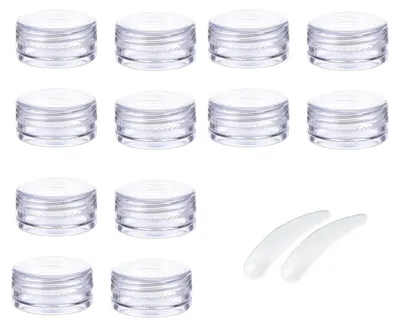 A collection of clear plastic cosmetic containers and two small scoops are arranged on a white background.