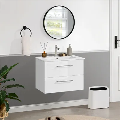 A modern bathroom vanity with a sink and faucet, a round mirror, a towel rack, and a trash can.