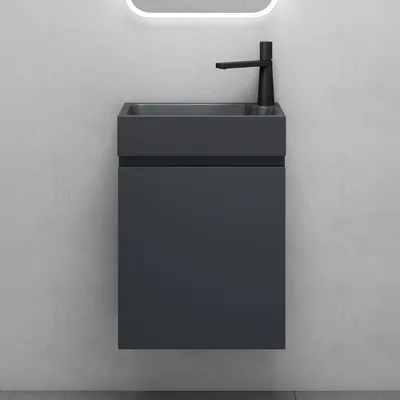 A modern bathroom vanity set with a mineral cast sink and a wall-mounted cabinet in matte anthracite, set against a textured gray wall.