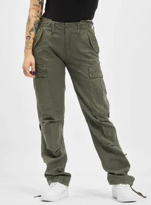 A person wearing olive green cargo pants and white sneakers against a white background.