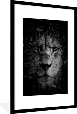 Produktbild von MuchoWow® Gerahmtes Poster Nahaufnahme eines Löwen mit Blättern im Dschungel - schwarz und weiß 60x90 cm - Poster mit Schwarzem Bilderrahmen Wandposter Rahmen Foto Bilder - Dekoration - Wandposter Wohnzimmer - Hochwertig