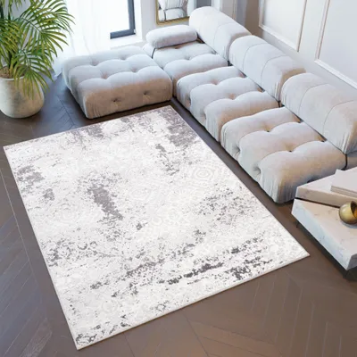 A modern living room with a large sectional sofa and a rug.