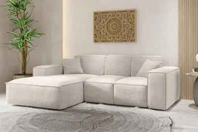 A beige sectional sofa in a modern living room setting, with a potted plant and a wooden wall art.