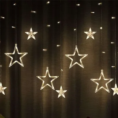 A string of star-shaped lights hanging against a dark, textured background.