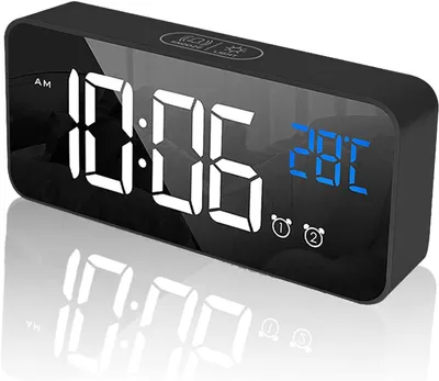 A digital alarm clock with a mirrored display showing the time and temperature.