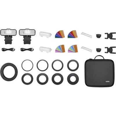 A flat lay of camera accessories, including flashes, diffusers, color gels, and a carrying case.
