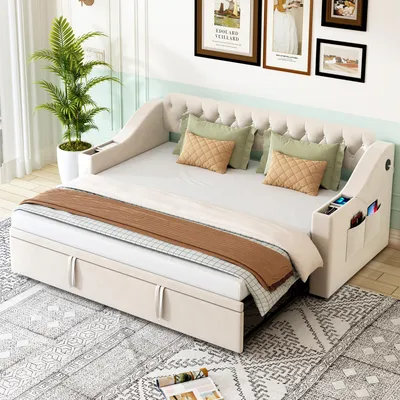 A beige upholstered sofa bed with storage drawers and integrated armrest storage, styled with pillows and a throw blanket in a room setting.