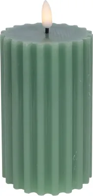 A close-up studio shot of a green LED pillar candle with a fluted texture and a flickering LED flame.