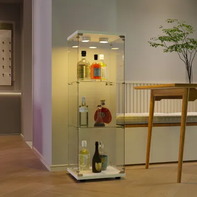 A glass display cabinet with bottles on shelves, next to a table and a plant.