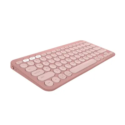 A pink Logitech Pebble Keys 2 K380s keyboard is shown from a slightly elevated side angle against a white background.