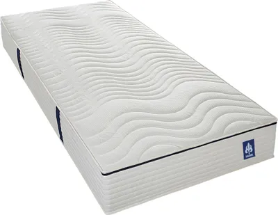 A white mattress with a wavy pattern on top, shown from a diagonal angle.