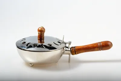 A silver incense burner with a wooden handle and lid, set against a white background.
