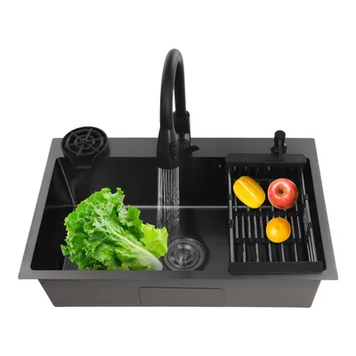 A black kitchen sink with a faucet running water, a head of lettuce, and some fruit in a drying rack.