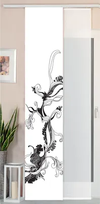 A sliding curtain panel with a black floral design on a white background, displayed in a room setting with a plant and a lantern.