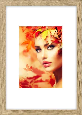 A woman with autumn leaves in her hair, with a blurred background of autumn leaves.