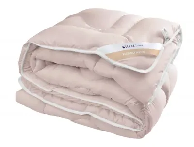 A folded pink blanket with a white trim and a label.