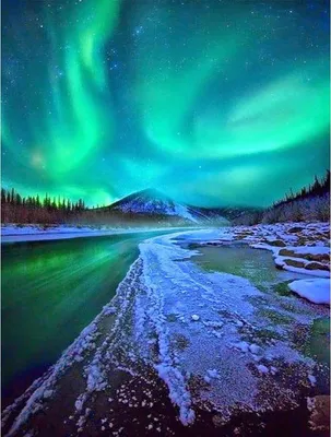 A stunning natural landscape featuring the aurora borealis over a snow-covered river and mountains.