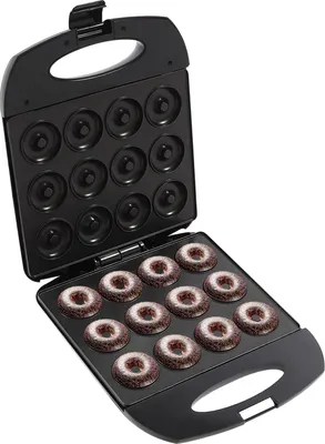 An open donut maker with 12 freshly baked chocolate donuts dusted with powdered sugar.