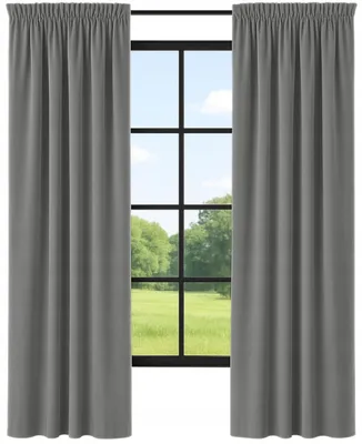 A pair of dark gray curtains hanging in front of a window with a view of a green field and trees.