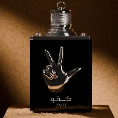 A close-up shot of a black perfume bottle with a silver hand gesture emblem and Arabic text.