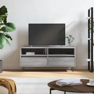 A modern living room scene featuring a TV stand with a television on top, a large potted plant, and a bookshelf in the background.