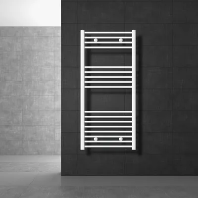 A white towel radiator is mounted on a black tiled wall, with a gray tiled wall and floor in the background.