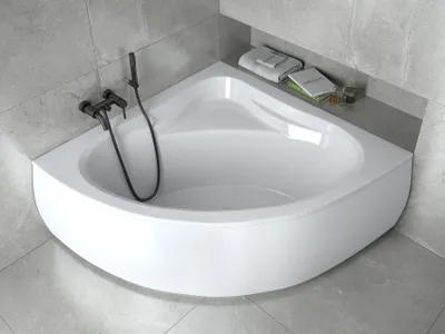 A white corner bathtub with a black faucet and shower head, set against a tiled wall.