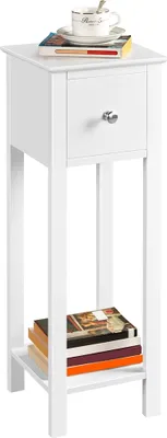 A white wooden nightstand with a drawer and two shelves, displaying a stack of books on the bottom shelf and a cup of tea on top.