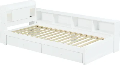 A white wooden bed frame with a slatted mattress base, drawers underneath, and a bookshelf headboard.