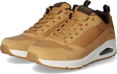 A pair of tan and brown Skechers sneakers are shown against a white background.