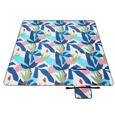 A flat lay of a picnic blanket with a colorful abstract leaf pattern.
